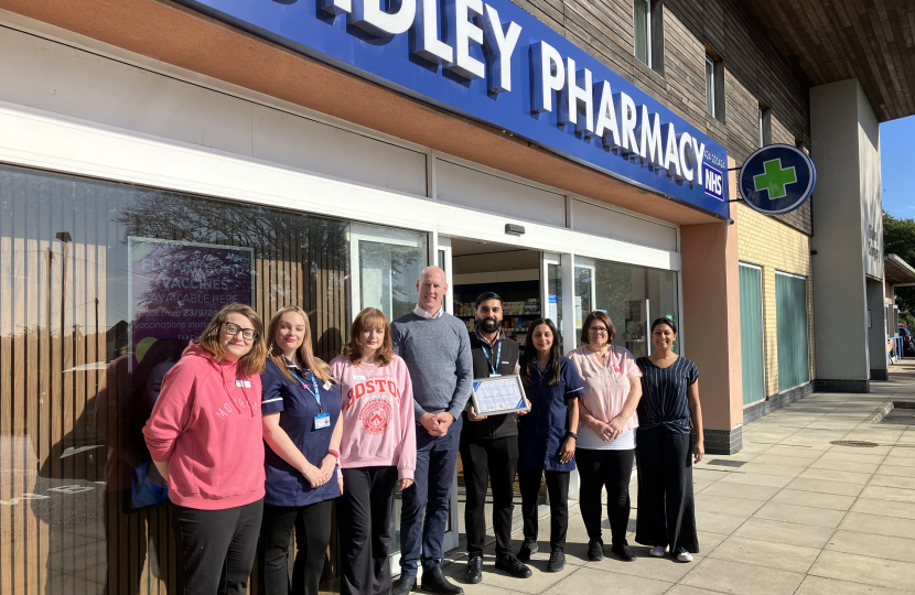 Kieran with Sukhy Uppal and the Sidley pharmacy teamm standing outside Sidley pharmacy