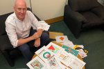 Kieran sitting in front of Christmas card competiton entries