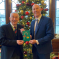 Kieran and Speaker Sir Lindsay Hall holding winning Christmas card in front of Christmas tree in Speakers House